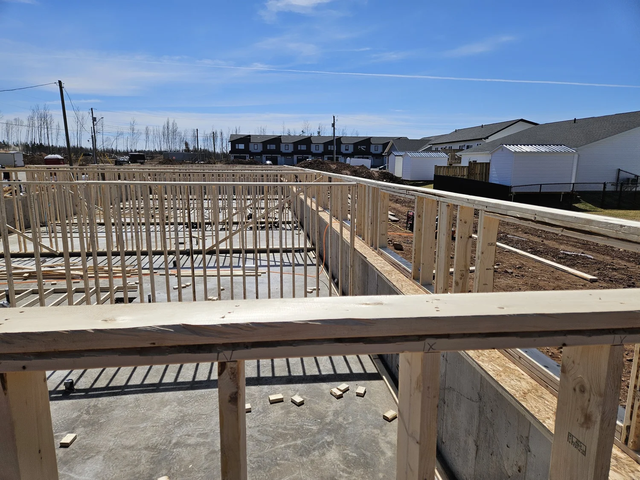Early-stage wood framing of a residential multi unit building, basemeant fire walls framed.