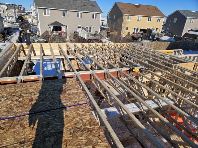 Floor joists and beams framed for a residential foundation, showing structural layout and support system.
