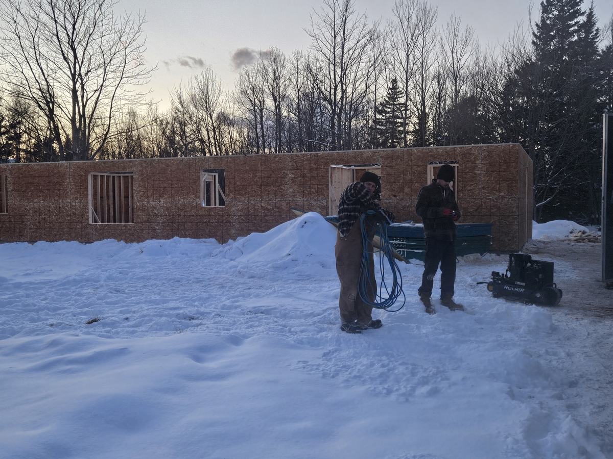 Construction crew conducting site work on a home project during winter conditions.