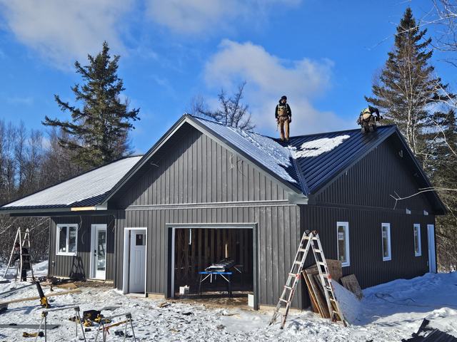 Workers installing metal roofing.