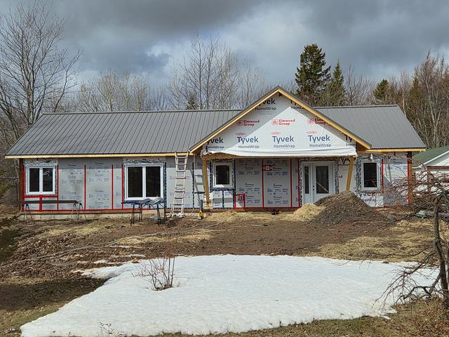 Single-storey home framing completed. Metal roof installed and exterior foam cladding on ready for siding