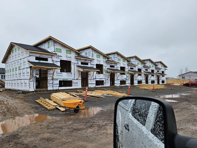 Multi-unit townhomes wrapped in Tyvek house wrap during the framing stage.
